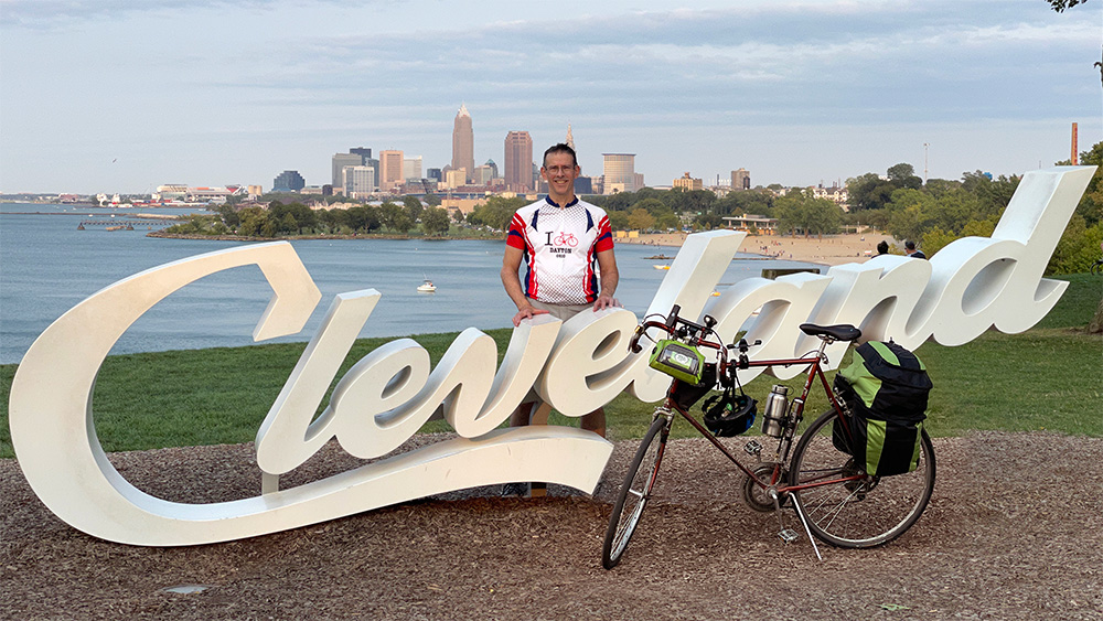 The author standing at the script Cleveland sign at Edgewater Park